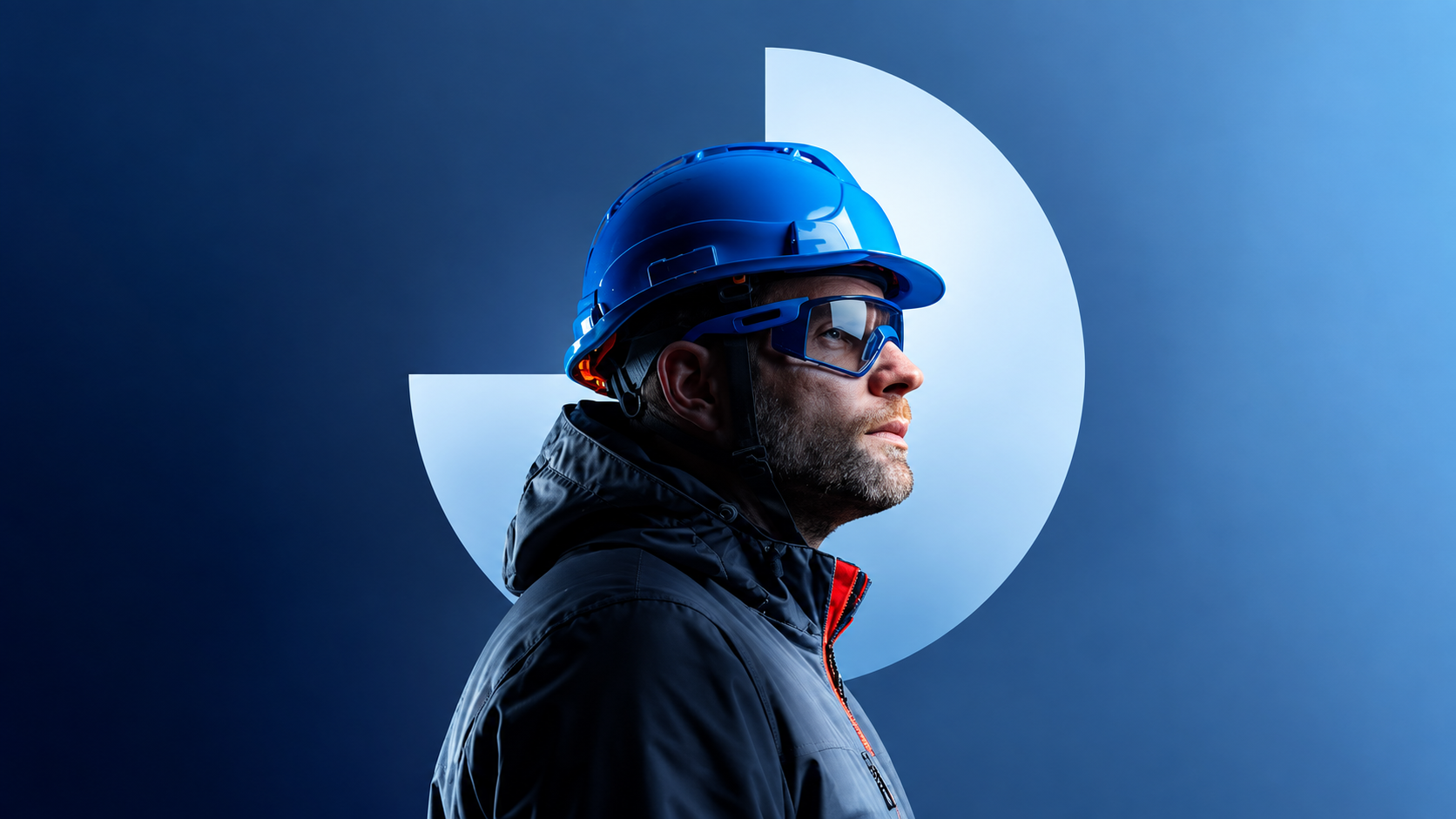 Engineer in a blue safety helmet and protective glasses, in profile
