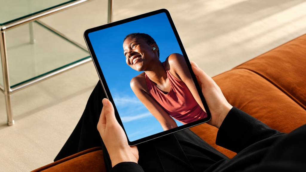 Hands holding a tablet showing a portrait photo, in a relaxed home setting